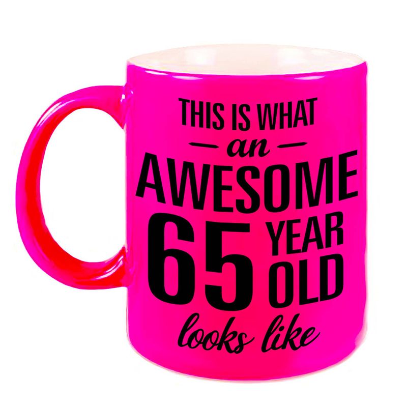 Foto van Awesome 65 year cadeau mok / beker neon roze 330 ml - feest mokken